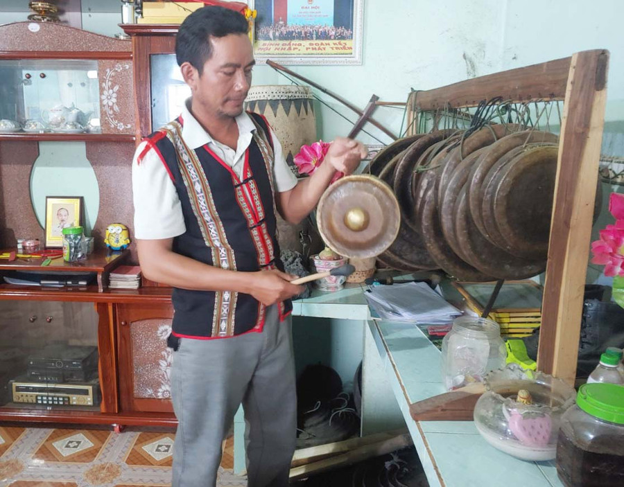 Anh Đinh Vin bên những bộ chiêng của gia đình. Ảnh: R’Ô HOK 