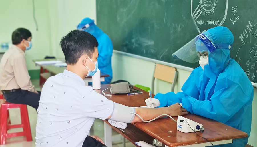  Kiểm tra sức khỏe người dân trước khi tiêm vắc xin phòng Covid-19. Ảnh: Bá Bính