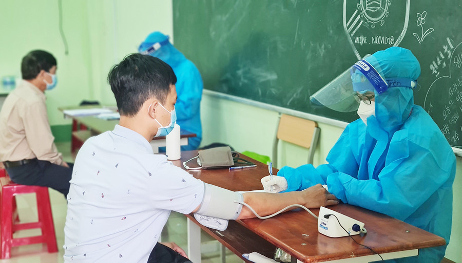  Kiểm tra sức khỏe người dân trước khi tiêm vắc xin phòng Covid-19. Ảnh: Bá Bính