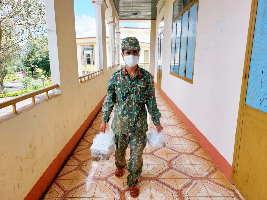 Chiến sĩ mang cơm đến tận phòng cho người cách ly. Ảnh: Vĩnh Hoàng