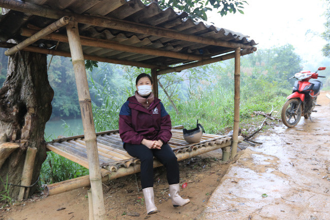 Cô Tính - Hiệu trưởng cấp 2 Yên Lỗ ngồi đợi học sinh qua sông. Ảnh: G.T