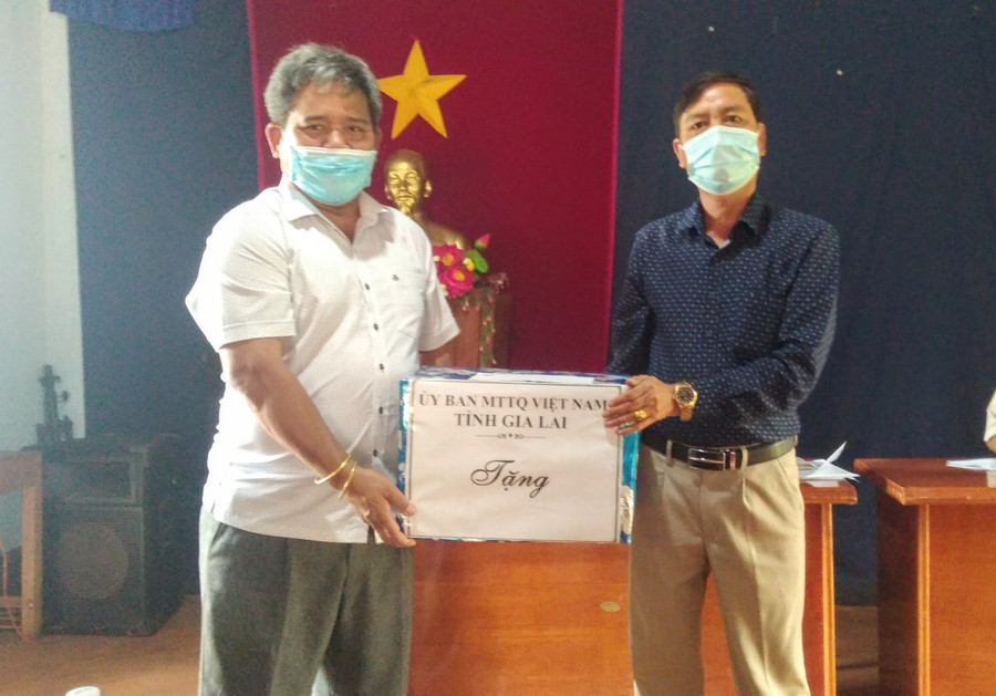 Chủ tịch Uỷ ban MTTQ Việt Nam tỉnh Hồ Văn Điềm (bìa trái) tặng quà cho Chi bộ thôn Tân Tiến. Ảnh: Lê Đại