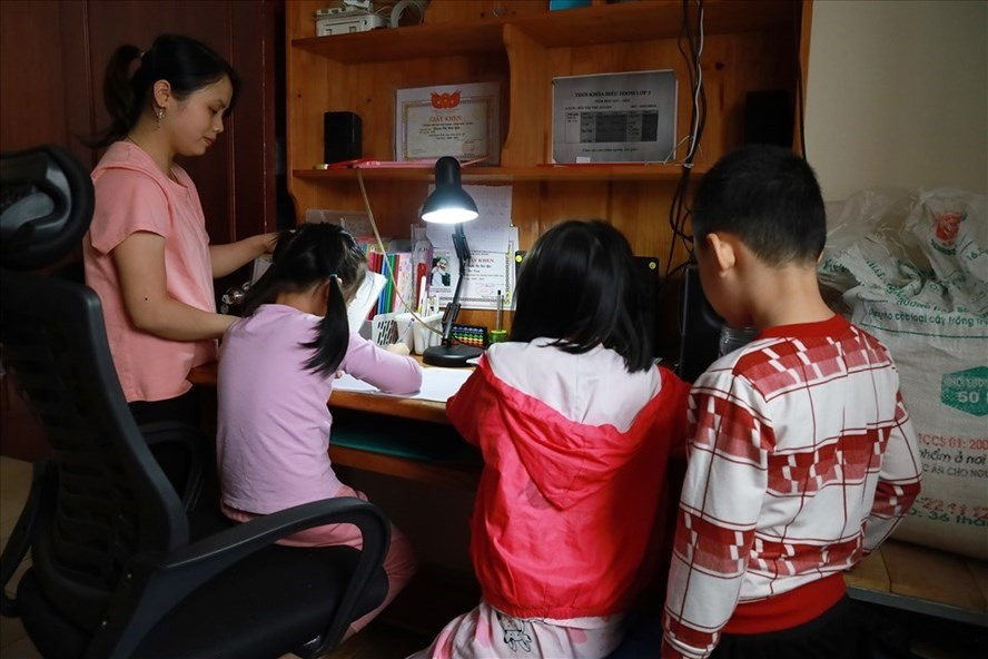 Một phụ huynh hướng dẫn con học trực tuyến Ảnh: Lao Động