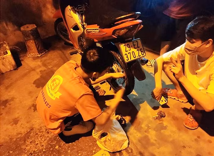 Chiếc xe máy của người đi đường bị hỏng tại phố Quan Nhân, Thanh Xuân đang được giải cứu.