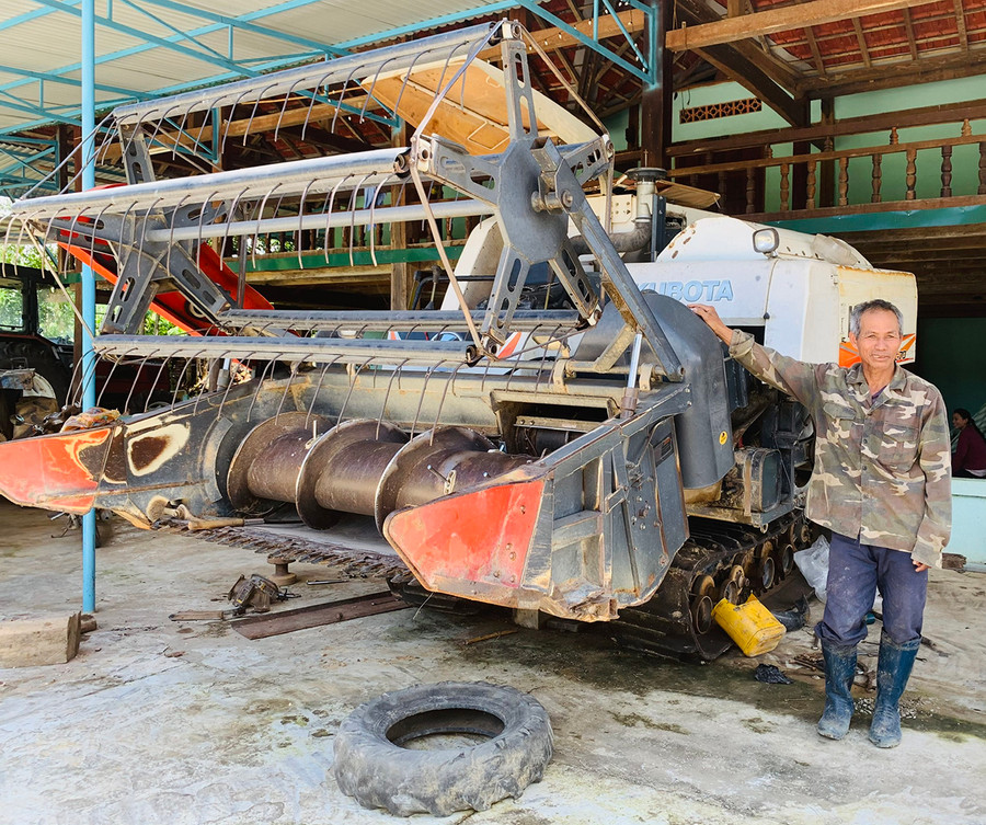 Ông Sut bên chiếc máy gặt đập liên hợp của gia đình. Ảnh: Nhật Hào Ông Sut bên chiếc máy gặt đập liên hợp của gia đình. Ảnh: Nhật Hào