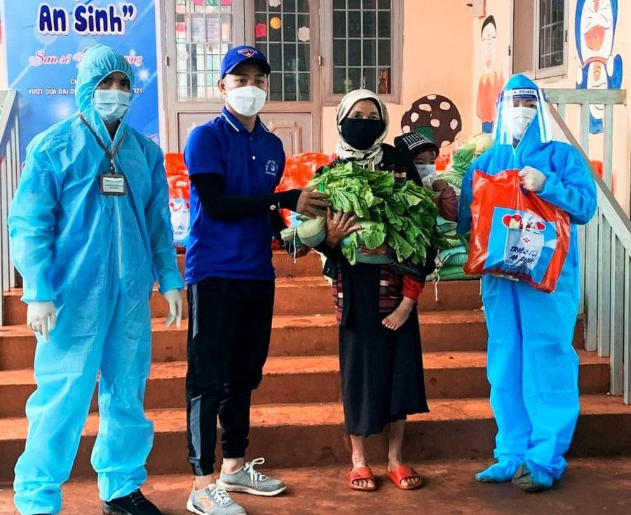 Anh Bình (thứ 2, từ trái sang) trao quà cho người dân trong chương trình Triệu túi an sinh. Ảnh: NVCC