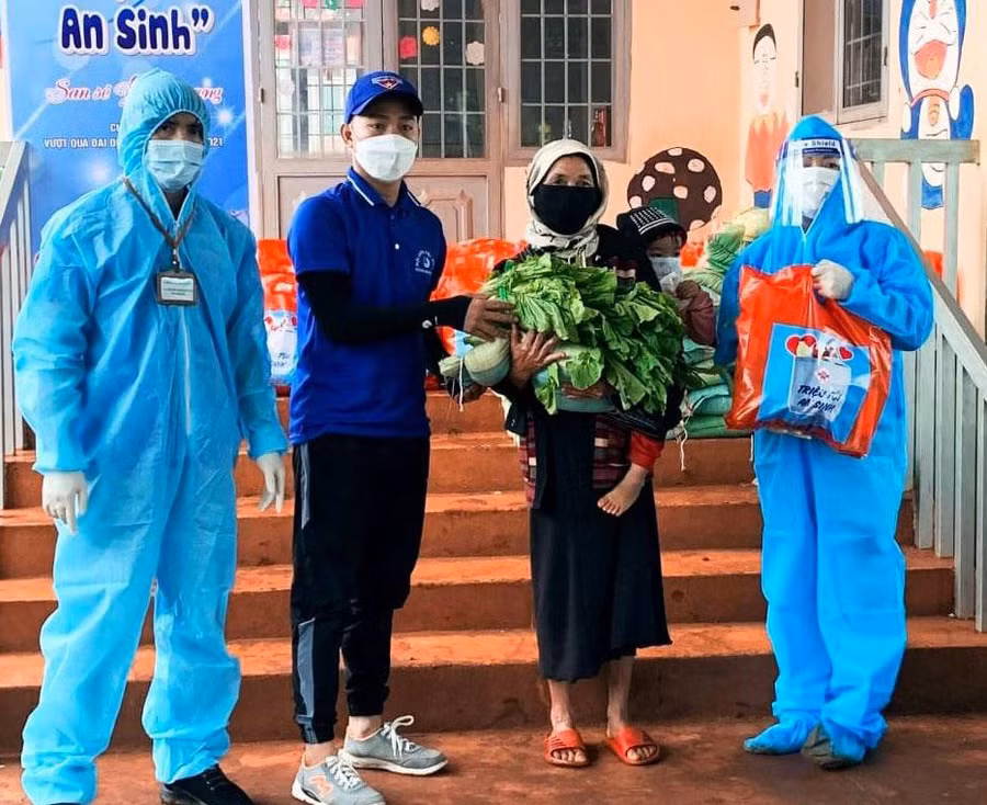 Anh Bình (thứ 2, từ trái sang) trao quà cho người dân trong chương trình Triệu túi an sinh. Ảnh: NVCC