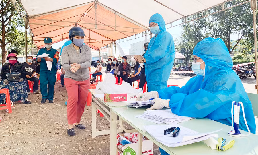 Người dân tuân thủ các quy định phòng-chống dịch tại điểm tiêm chủng vắc xin phòng Covid-19 phường Yên Đổ, TP. Pleiku. Ảnh: Như Nguyện