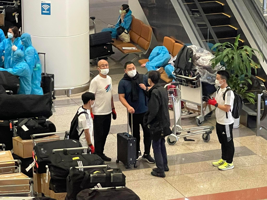 Những người mặc áo bảo hộ xanh là nhân viên sân bay, hỗ trợ đội Nhật Bản lấy hành lý