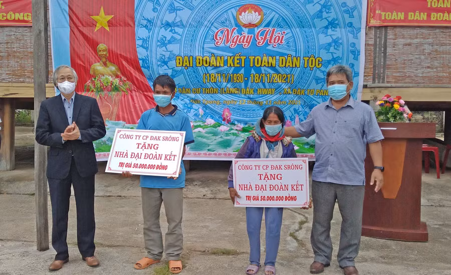  Ông Nguyễn Đức Tuấn (bìa trái)-Giám đốc Công ty cổ phần Đak Srông trao tặng 2 căn nhà Đại đoàn kết cho 2 hộ nghèo của làng Đak Hway. Ảnh: Lê Đại