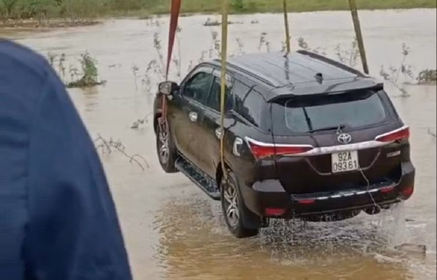 Chiếc ô tô bị nước lũ cuốn trôi được trục vớt, đưa lên bờ. Ảnh: C.X