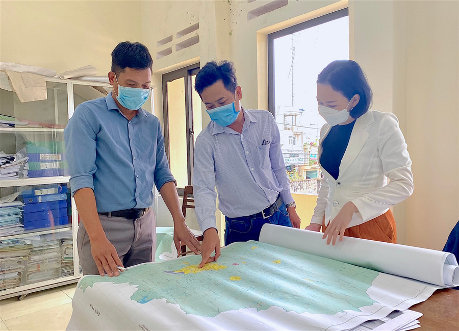 Ông Nguyễn Trung Phát-Trưởng phòng Điều tra, Liên đoàn Quy hoạch và Điều tra Tài nguyên nước Miền Trung (giữa) phân tích các hướng chảy của nước ở Phố núi Pleiku qua bản đồ. Ảnh: Tấn Thi