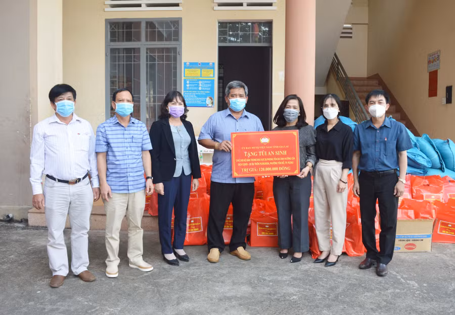 Chủ tịch Ủy ban MTTQ Việt Nam tỉnh trao bảng tượng trưng cho lạnh đạo UBND phường Yên Đổ. Ảnh: Anh Huy