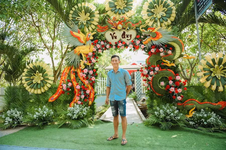 Anh Tâm bên cổng cưới rồng phụng đẹp mắt do anh thiết kế. Ảnh: Duy Tân