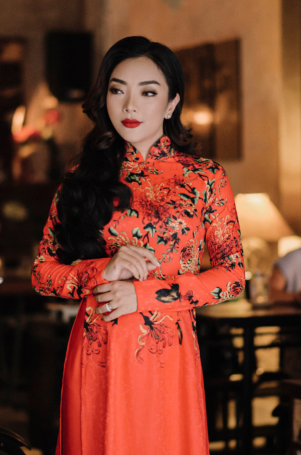 Ca sĩ Lều Phương Anh mặc áo dài cam, họa tiết hoa lá.