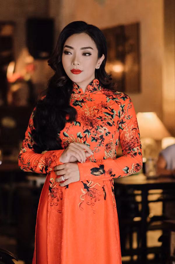 Ca sĩ Lều Phương Anh mặc áo dài cam, họa tiết hoa lá.