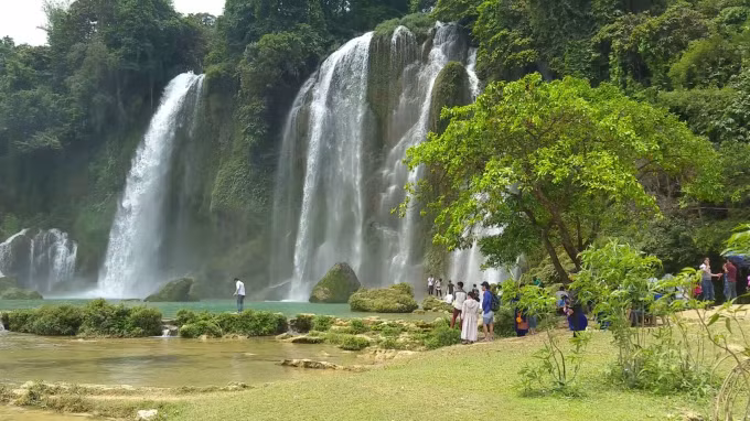 Cảnh thác chảy từ trên cao hòa quyện núi đá nhấp nhô cùng cỏ cây, hoa lá... tạo nên bức tranh như vẽ thu hút người xem.
