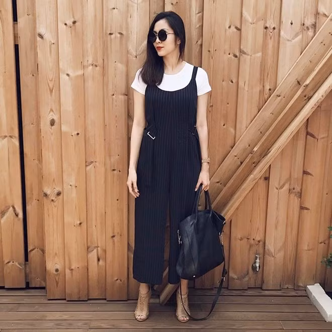 Chỉ từ những item cơ bản như áo phông trắng, jumpsuit đen và giày cao gót, Tăng Thanh Hà đã tạo được phép cộng tuyệt vời, có thể làm bật vẻ ngoài thanh lịch, thời thượng. Thiết kế jumpsuit dáng quần yếm với chi tiết nhấn nhá ở hai bên eo còn giúp ''ngọc nữ'' tôn vóc dáng mảnh mai, nuột na như thời son rỗi.