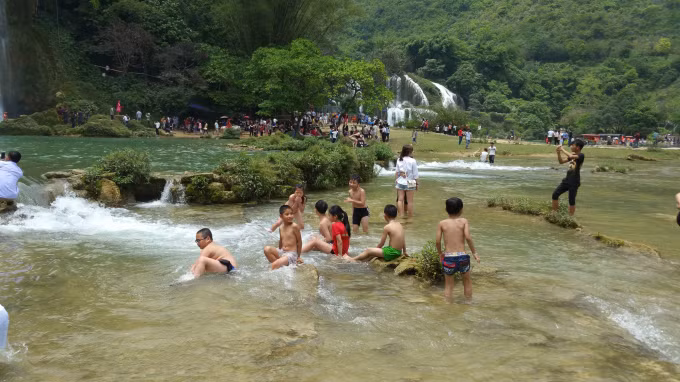 Bên cạnh thác, nhiều trẻ em dầm mình dưới suối tỏ vẻ thích thú.