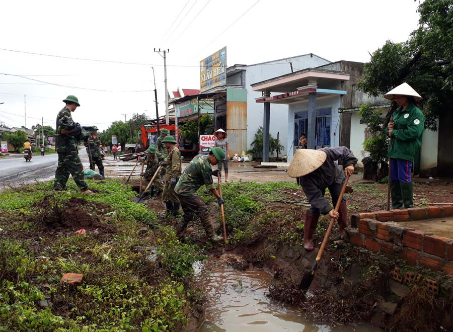  Thanh niên, nhân dân xã Ia Nhin (huyện Chư Pah) và bộ đội Trung đoàn 52 khơi thông cống thoát nước bị ứ đọng do mưa. Ảnh: N.T