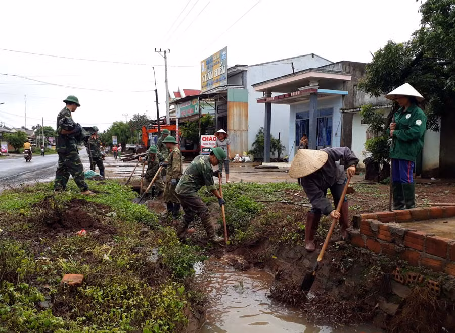  Thanh niên, nhân dân xã Ia Nhin (huyện Chư Pah) và bộ đội Trung đoàn 52 khơi thông cống thoát nước bị ứ đọng do mưa. Ảnh: N.T