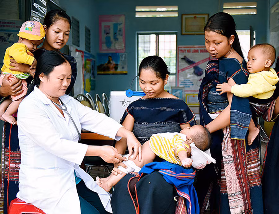  Cán bộ y tế xã Tơ Tung (huyện Kbang) chăm sóc sức khỏe cho trẻ em. Ảnh: Đức Thụy