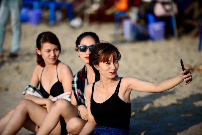 Ngày hè, nhiều người đi tắm biển thích vui đùa thỏa thích trên cát, dưới ánh nắng, nên chú ý bảo vệ da dưới ánh nắng mặt trời Ngày hè, nhiều người đi tắm biển thích vui đùa thỏa thích trên cát, dưới ánh nắng, nên chú ý bảo vệ da dưới ánh nắng mặt trời