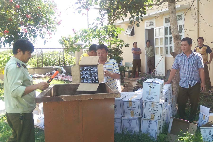 Lực lượng Quản lý Thị trường tiêu hủy rượu vi phạm. Ảnh: Lê Lan  Lực lượng Quản lý Thị trường tiêu hủy rượu vi phạm. Ảnh: Lê Lan