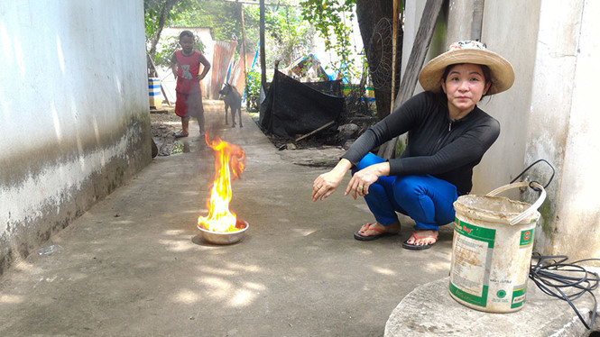 Chị Chi châm lửa vào ca nước múc từ giếng của gia đình thì nước bốc cháy.