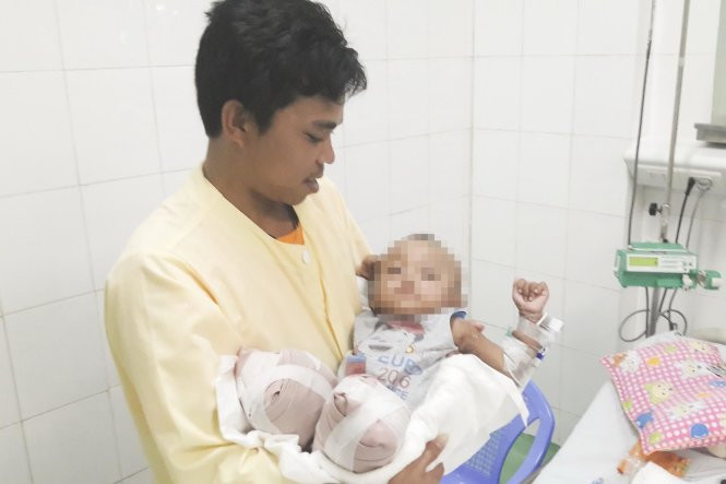 Bé Quốc Quân trong vòng tay cha