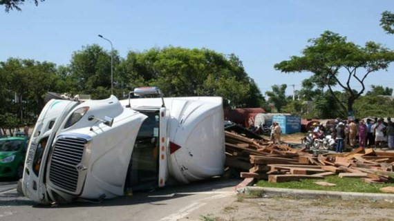 Hiện trường xe đầu kéo chở gỗ bị lật ngang khiến QL1A bị ách tắc.