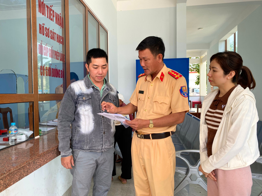 Cán bộ Phòng Cảnh sát giao thông Công an tỉnh Gia Lai hướng dẫn người dân thực hiện thủ tục đổi, cấp lại giấy phép lái xe. Ảnh: Nguyễn Chơn huong-dan-nguoi-dan.jpg