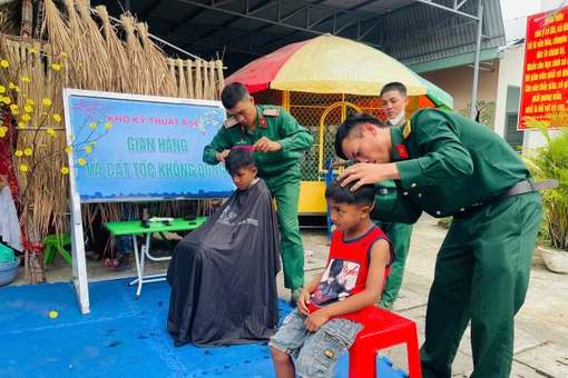 Cán bộ, chiến sĩ Kho Kỹ thuật K54 cắt tóc miễn phí cho trẻ em địa phương. Ảnh: Vũ Chi