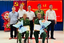 Lãnh đạo xã Canh Liên trao Huy hiệu 45 tuổi Đảng tặng các đảng viên. Ảnh: T.C