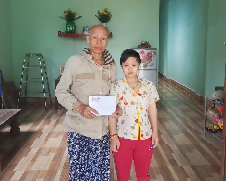 Gia đình bà Trần Thị Tuyết Nhung nhận 10,7 triệu đồng do bạn đọc hỗ trợ. Ảnh: Đồng Lai z6938681913852-1530afde69a6f69da39dd18d234d4040.jpg