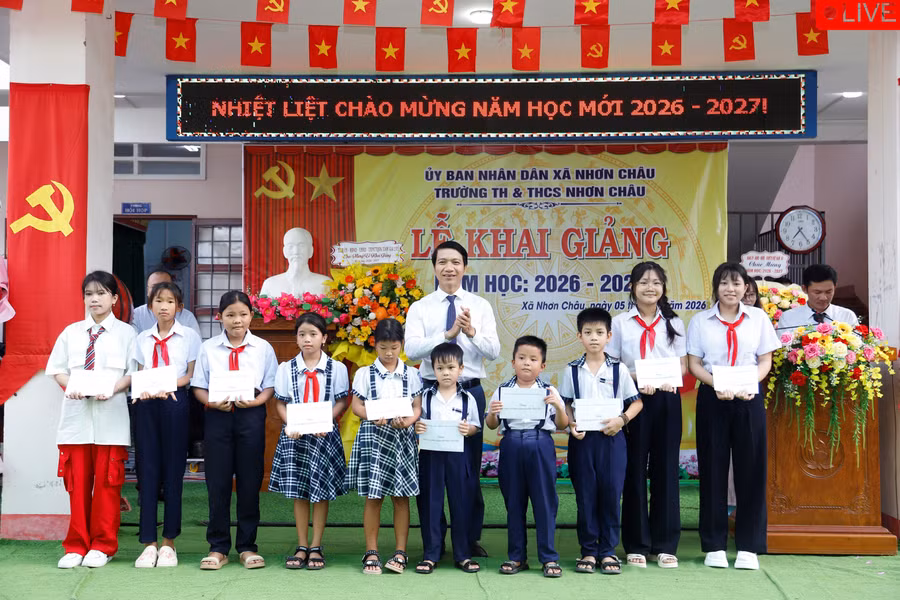 Phó Bí thư Tỉnh ủy Nguyễn Ngọc Lương trao học bổng cho học sinh Trường Tiểu học và THCS Nhơn Châu. Ảnh: H.P