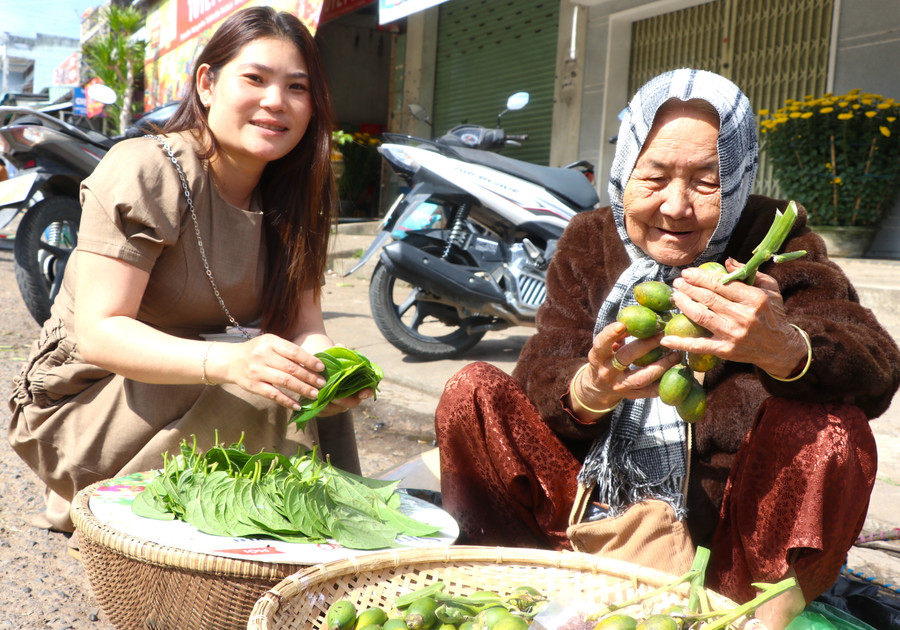 Chị Trần Thị Kim Ngọc (bìa trái, ở tổ 5, phường An Phú, thị xã An Khê) mua trầu, cau mong muốn rước tài lộc về nhà ngày đầu năm mới. Ảnh: Ngọc Minh