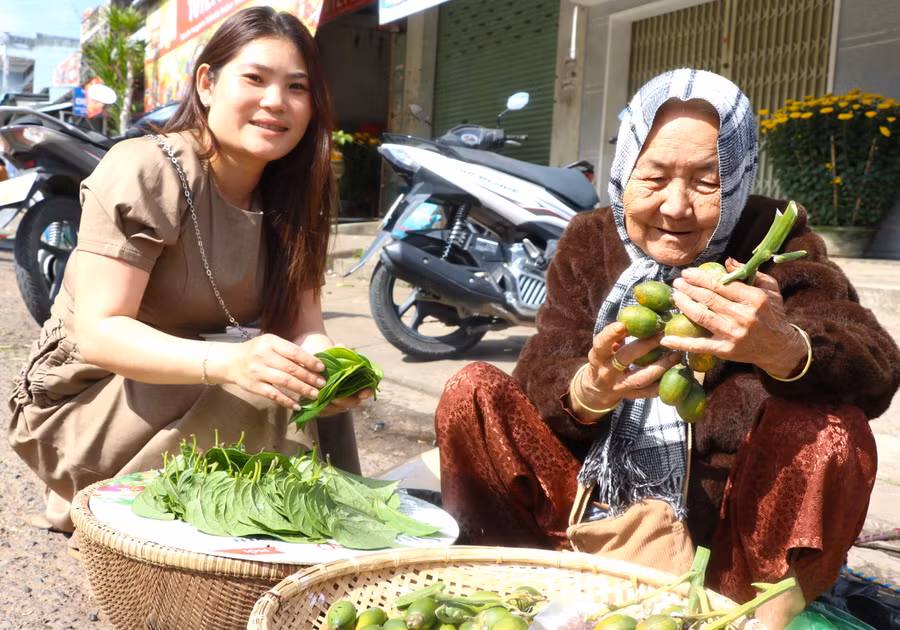 Chị Trần Thị Kim Ngọc (bìa trái, ở tổ 5, phường An Phú, thị xã An Khê) mua trầu, cau mong muốn rước tài lộc về nhà ngày đầu năm mới. Ảnh: Ngọc Minh