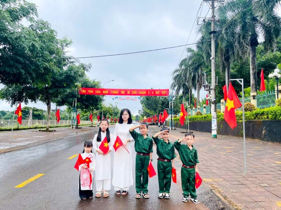Cô giáo và học sinh huyện biên giới Đức Cơ chụp ảnh lưu niệm bên đường cờ Tổ quốc trong dịp Tết Độc lập 2024. Ảnh: Nam Lê