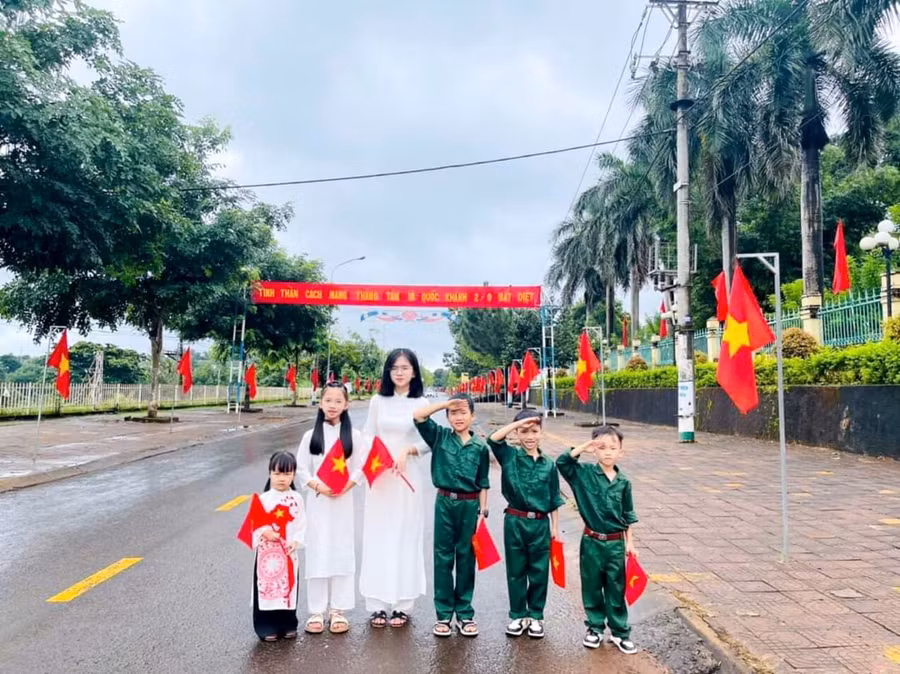 Cô giáo và học sinh huyện biên giới Đức Cơ chụp ảnh lưu niệm bên đường cờ Tổ quốc trong dịp Tết Độc lập 2024. Ảnh: Nam Lê
