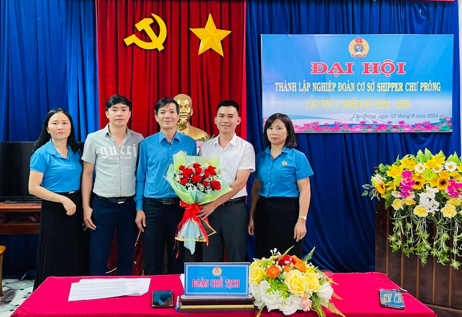 Chủ tịch LĐLĐ huyện Chư Prông Phạm Ngọc Toàn (đứng giữa) tặng hoa chúc mừng Ban Chấp hành Nghiệp đoàn Shipper Chư Prông. Ảnh: Văn Toàn