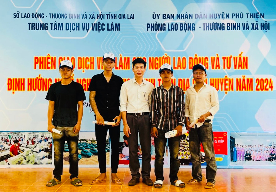 Ông Nguyễn Văn Đức (đứng giữa)-Giám đốc Công ty Xuất khẩu lao động MD Việt Nam chụp ảnh cùng người lao động và học sinh tại phiên giao dịch việc làm xã Ia Peng, huyện Phú Thiện. Ảnh: V. Đ