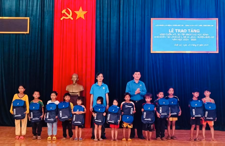 Các đơn vị trao cặp sách cho con cháu học sinh ở làng Le 1, Ảnh: Thanh Tịnh