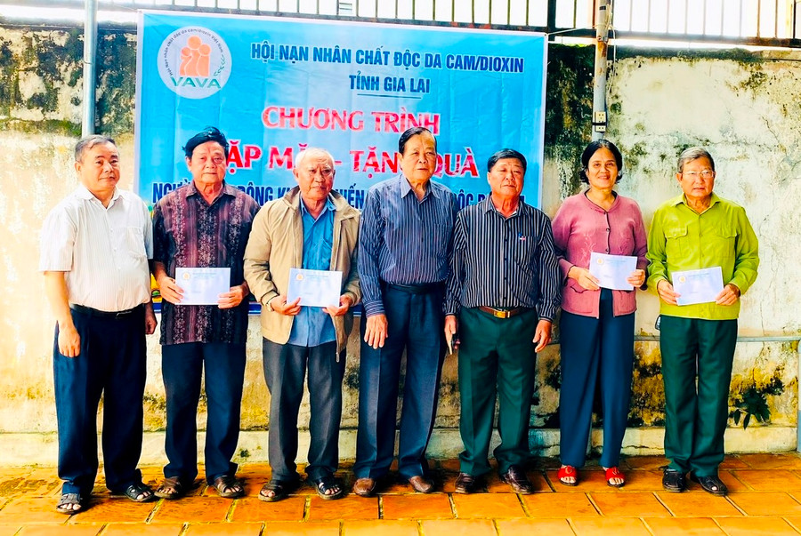 Ông Bùi Thanh Hoàng (thứ 4 từ phải qua) tặng quà cho các nạn nhân. Ảnh. Đ.Y