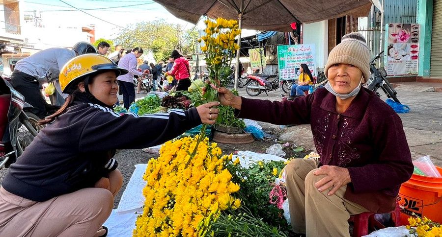 Sáng mùng 2 Tết, chị Nguyễn Thị Hoàng (bìa trái, đường Lê Thánh Tôn, tổ 10, phường Ia Kring, TP. Pleiku) chọn những nhành hoa cúc đẹp nhất mang về cúng tổ tiên, cầu mong mọi điều an lành, hạnh phúc, sức khỏe đến với gia đình. Ảnh: Đinh Yến