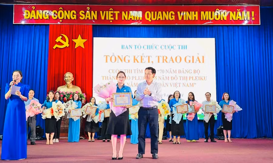 Chủ tịch UBND TP. Pleiku Đỗ Việt Hưng (bìa phải) trao giải nhất Cuộc thi cho cô giáo Phan Thị Hợp-đoàn viên Công đoàn cơ sở Trường Tiểu học Cù Chính Lan. Ảnh: Đinh Yến