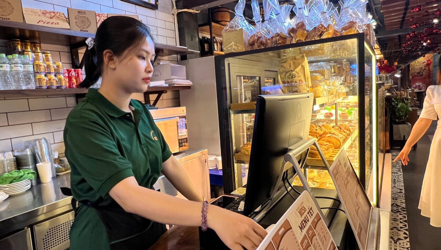 Em Trần Bửu Trân (275 đường Hùng Vương, TP. Pleiku; sinh viên năm nhất Khoa Tài chính ngân hàng, Trường Đại học Văn Hiến, TP. Hồ Chí Minh) làm công việc thu ngân tại quán Mase Bakery và Coffee ở 58 Nguyễn Văn Trỗi, TP. Pleiku. Ảnh: Đinh Yến