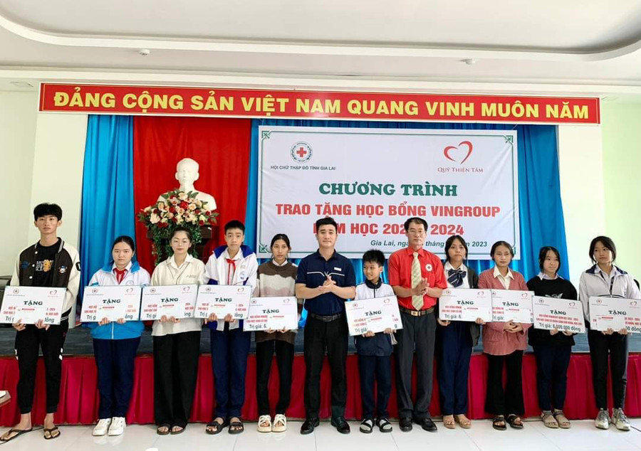 Ông Dương Đình Diện (thứ 5 từ phải sang)-Chủ tịch Hội Chữ thập đỏ Gia Lai cùng đại diện Qũy Thiện Tâm-Tập đoàn Vingroup trao học bổng cho các em học sinh. Ảnh: Đ.D