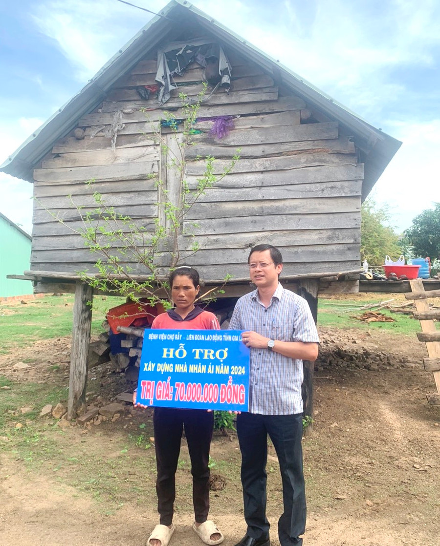 Ông Nguyễn Hoàng Phong-Tỉnh ủy viên, Chủ tịch LĐLĐ tỉnh Gia Lai trao tiền hỗ trợ sửa chữa nhà ở cho gia đình chị Đinh Nenh. Ảnh: Mỹ Lệ