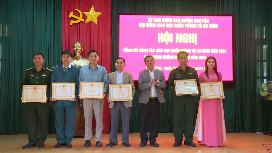 Ông Nguyễn Ngọc Thanh (thứ 3 từ phải qua)-Phó Chủ tịch UBND huyện Chư Păh tặng giấy khen cho các tập thể, cá nhân có thành tích tốt trong công tác giáo dục quốc phòng và an ninh năm 2023. Ảnh: V.Đ
